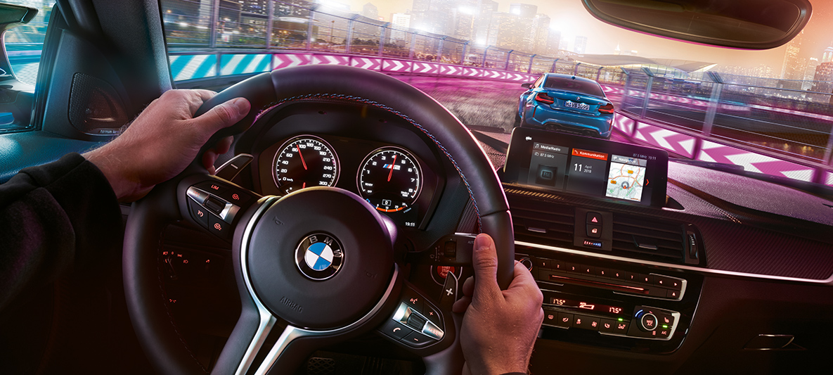 Interior do BMW M2 Competition Dois BMW M2 Competition em competição noturna, visto do interior.