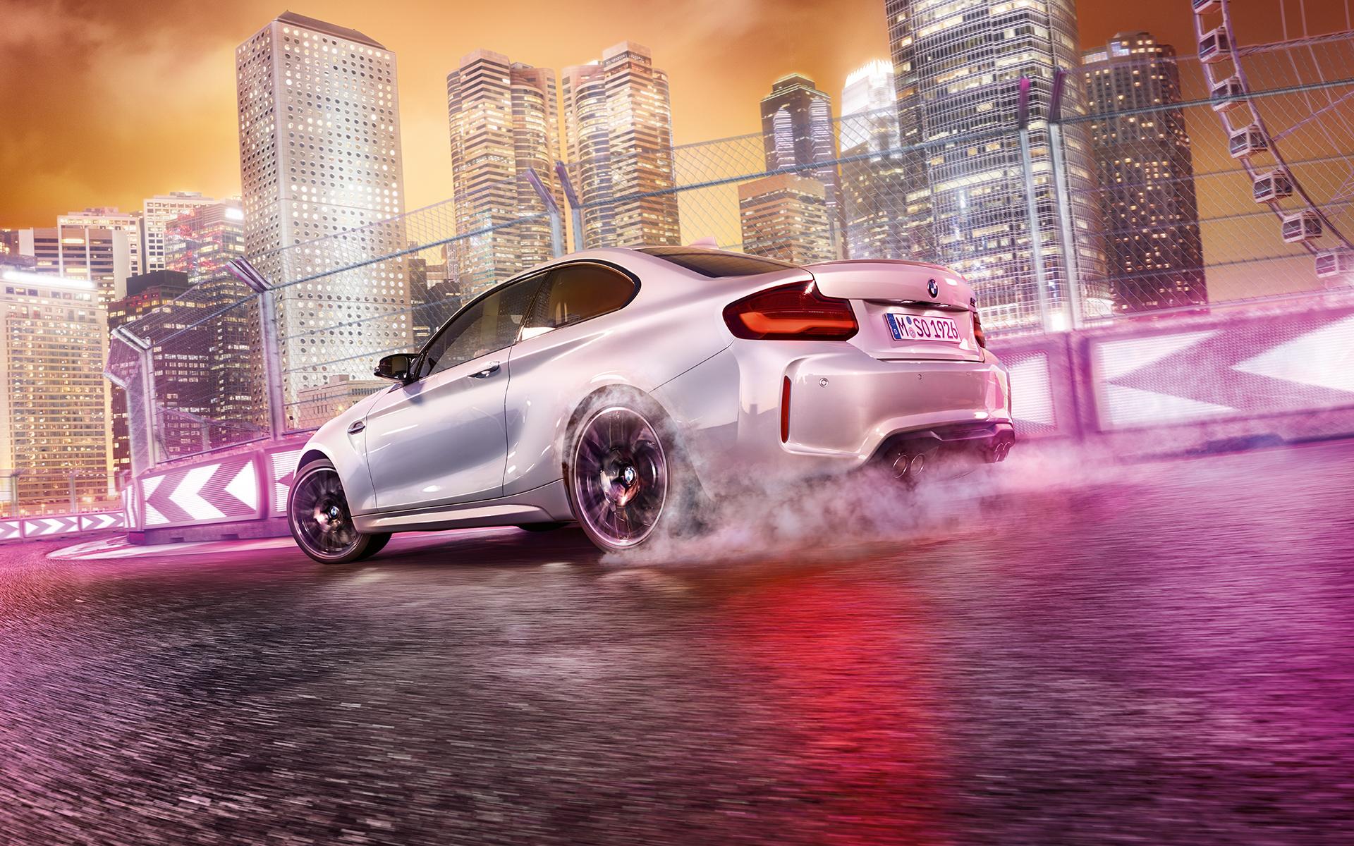 BMW M2 Competition em aceleração Um BMW M2 Competition branco em pista, frente a uma paisagem noturna com arranha-céus.