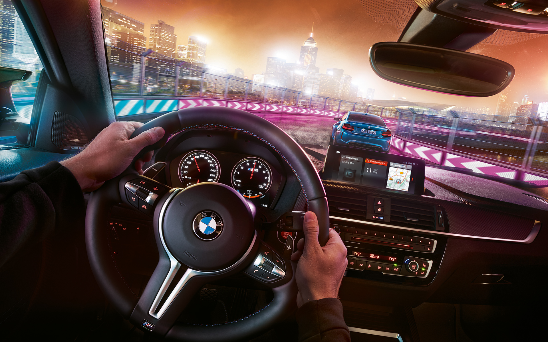 Interior do BMW M2 Competition Dois BMW M2 Competition em competição noturna, visto do interior.