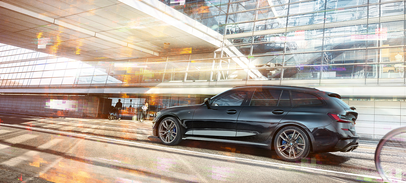 BMW M340i xDrive Touring, perspetiva lateral, em movimento, BMW M340i xDrive Touring, perspetiva lateral, em movimento, em frente a um edifício em vidro