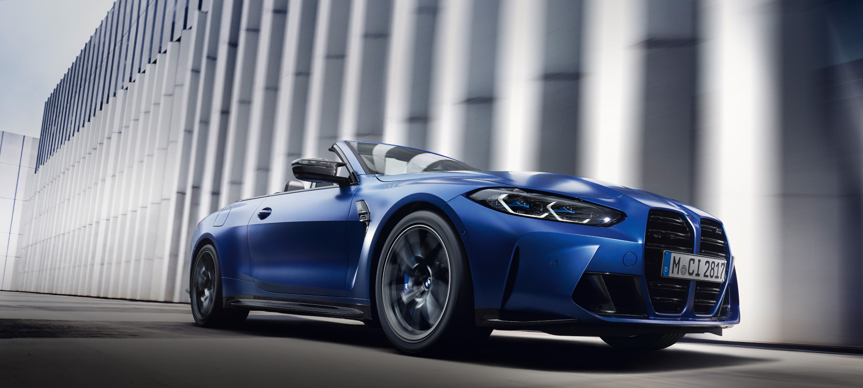 BMW M4 Competition Cabrio com M xDrive, G83, 2021, pintura azul Frozen Portimao metalizada BMW Individual, perspetiva frontal a três quartos, em movimento