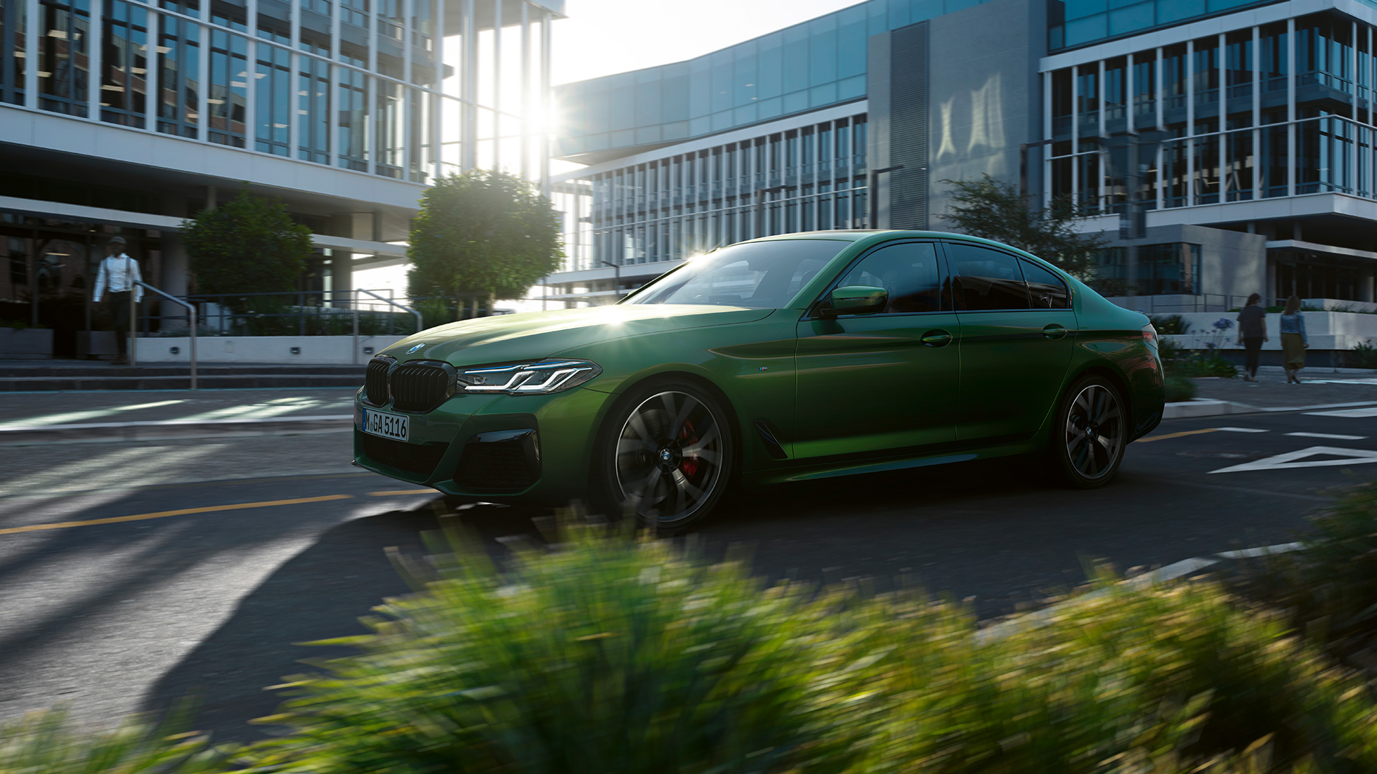 BMW M550i xDrive Berlina, G30 LCI, atualização, 2020, perspetiva lateral em movimento BMW M550i xDrive Berlina, G30 LCI, atualização, 2020, verde Ermes BMW Individual metalizado, perspetiva lateral em movimento na cidade