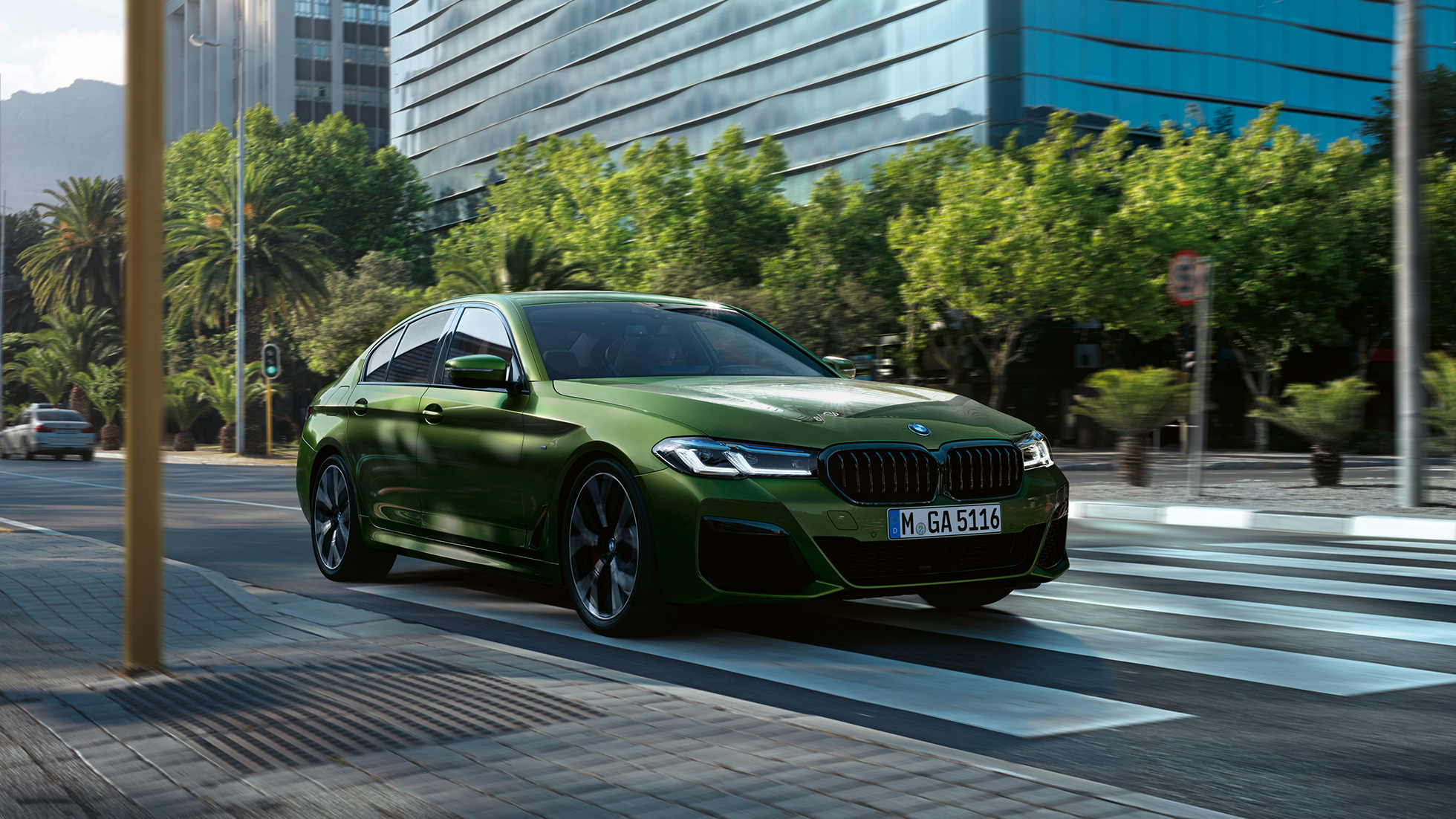 BMW M550i xDrive Berlina, G30 LCI, atualização, 2020, perspetiva frontal em movimento na cidade BMW M550i xDrive Berlina, G30 LCI, atualização, 2020, verde Ermes BMW Individual metalizado, perspetiva frontal em movimento na cidade