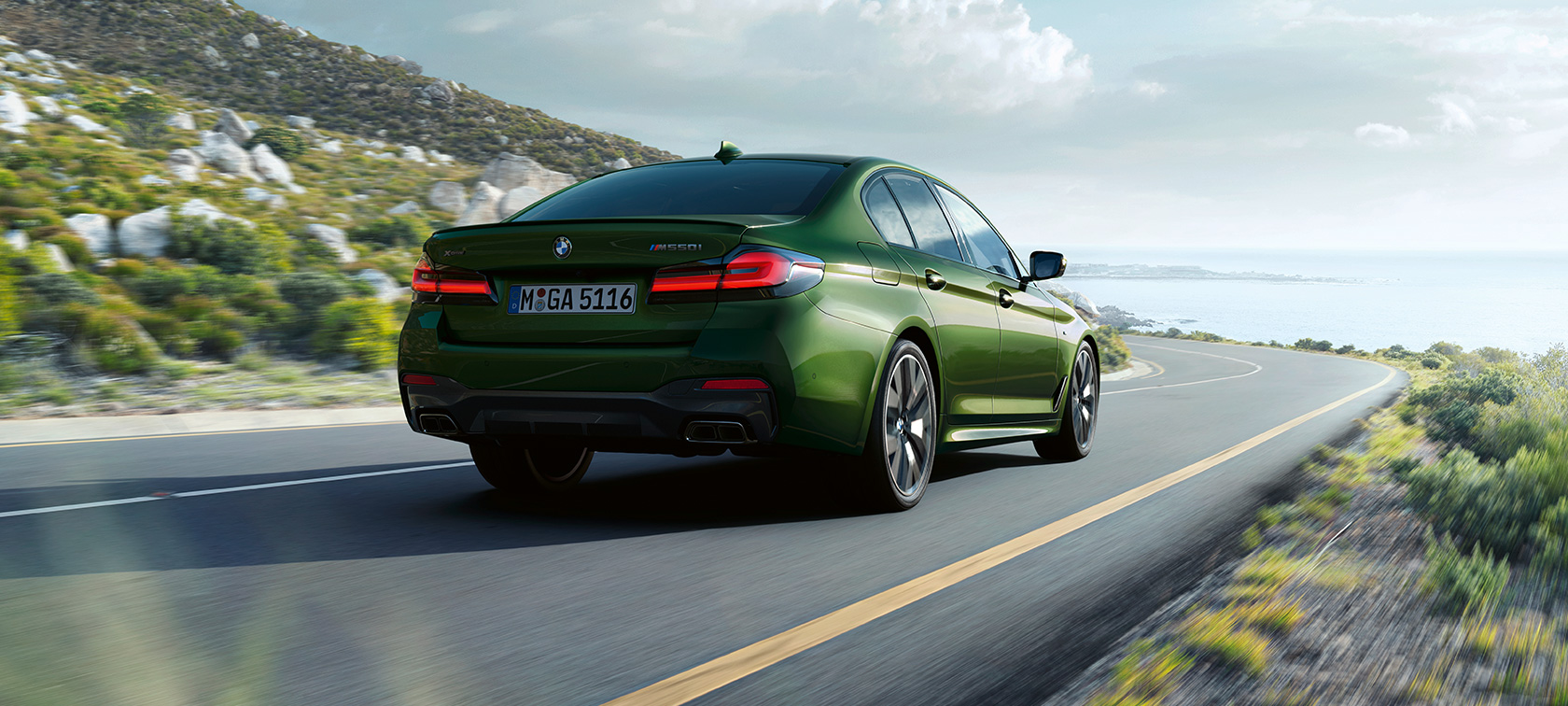 BMW M550i xDrive Berlina, G30 LCI, atualização, 2020, perspetiva traseira a três quartos em movimento BMW M550i xDrive Berlina, G30 LCI, atualização, 2020, verde Ermes BMW Individual metalizado, perspetiva traseira a três quartos em movimento