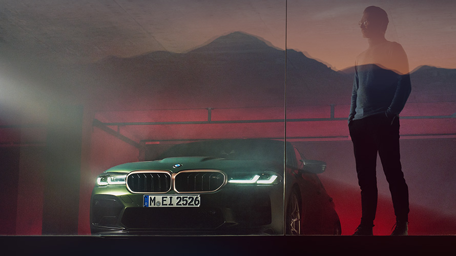 BMW M5 CS, F90, 2021, perspetiva frontal com um homem BMW M5 CS, F90, 2021, cor exterior verde Frozen Deep metalizada, perspetiva frontal com um homem
