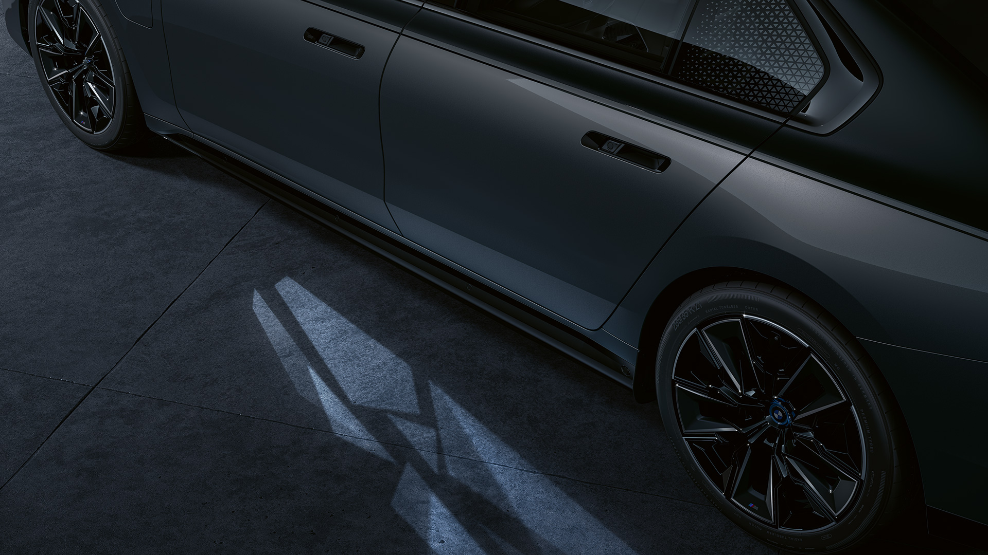Conceito de iluminação, BMW M760e xDrive Berlina, G70 Conceito de iluminação, BMW M760e xDrive Berlina, G70, pintura preto Sapphire BMW Individual de duas tonalidades metalizada, pintura cinza Dravite BMW Individual metalizada, perspetiva lateral, grande plano com o tapete de luzes de entrada ativado