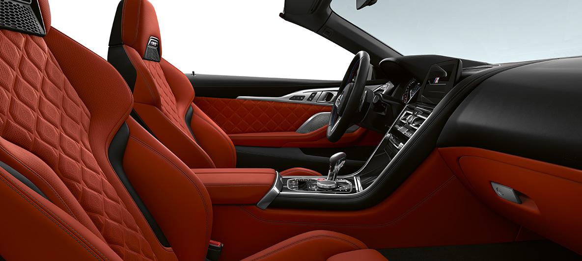 Estofos em pele integral Merino com grão fino | Laranja Sakhir e frisos interiores BMW Individual em preto Piano. BMW M8 Competition Cabrio, interior com estofos em pele integral Merino com grão fino | Laranja Sakhir e frisos interiores BMW Individual em preto Piano.
