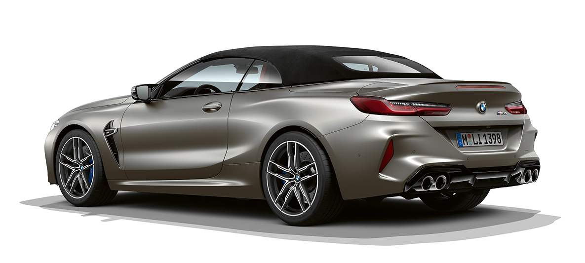 BMW M8 Cabrio, traseira, perspetiva lateral a três quartos. BMW M8 Cabrio na pintura prata Frozen Dark, traseira, perspetiva lateral a três quartos.