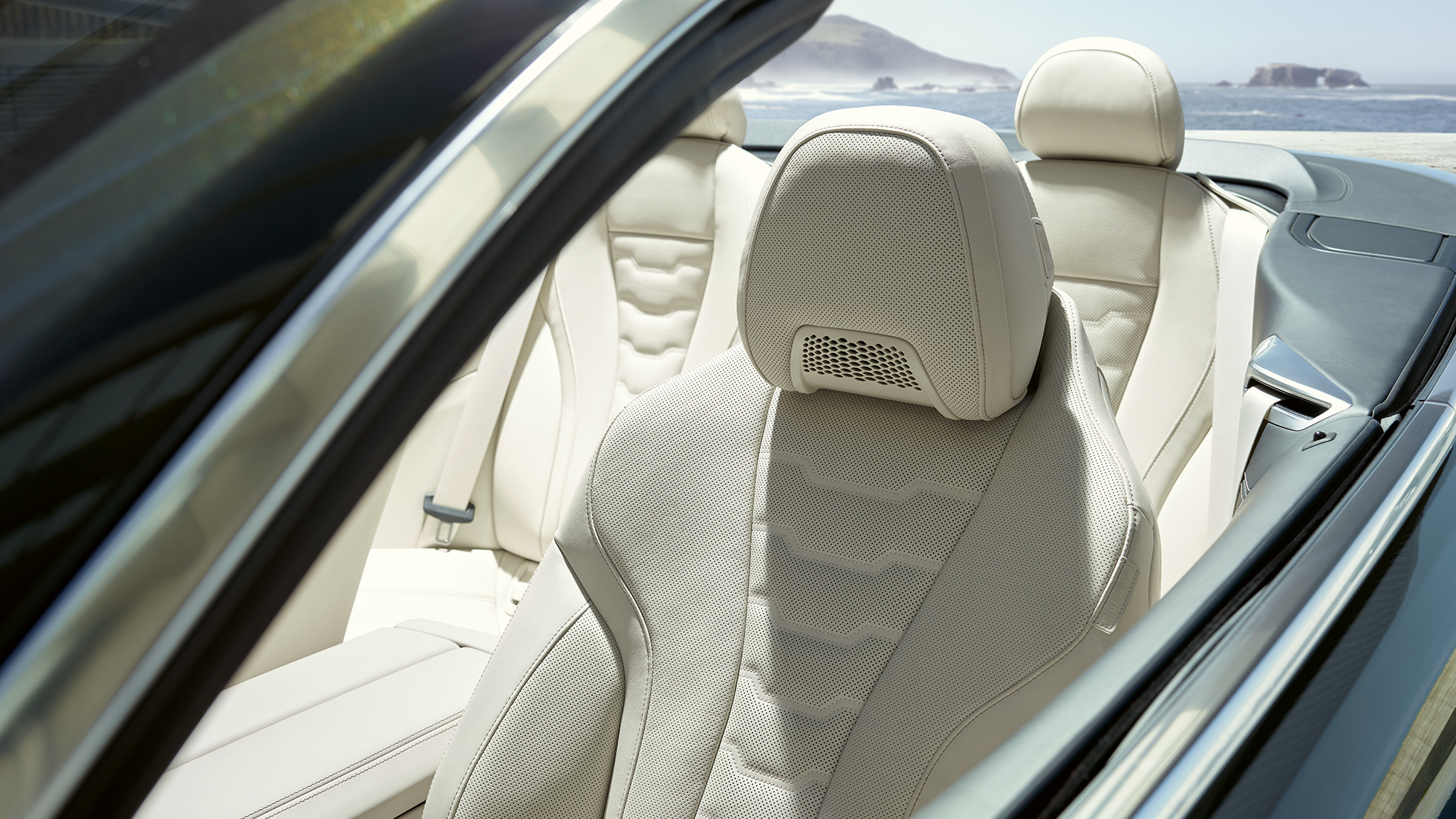 BMW M850i xDrive Cabrio, bancos multifuncionais para condutor e passageiro da frente. BMW M850i xDrive Cabrio em cinza Dravit metalizada com capota flexível aberta, interior com bancos multifuncionais em pele Merino BMW Individual em branco Ivory.