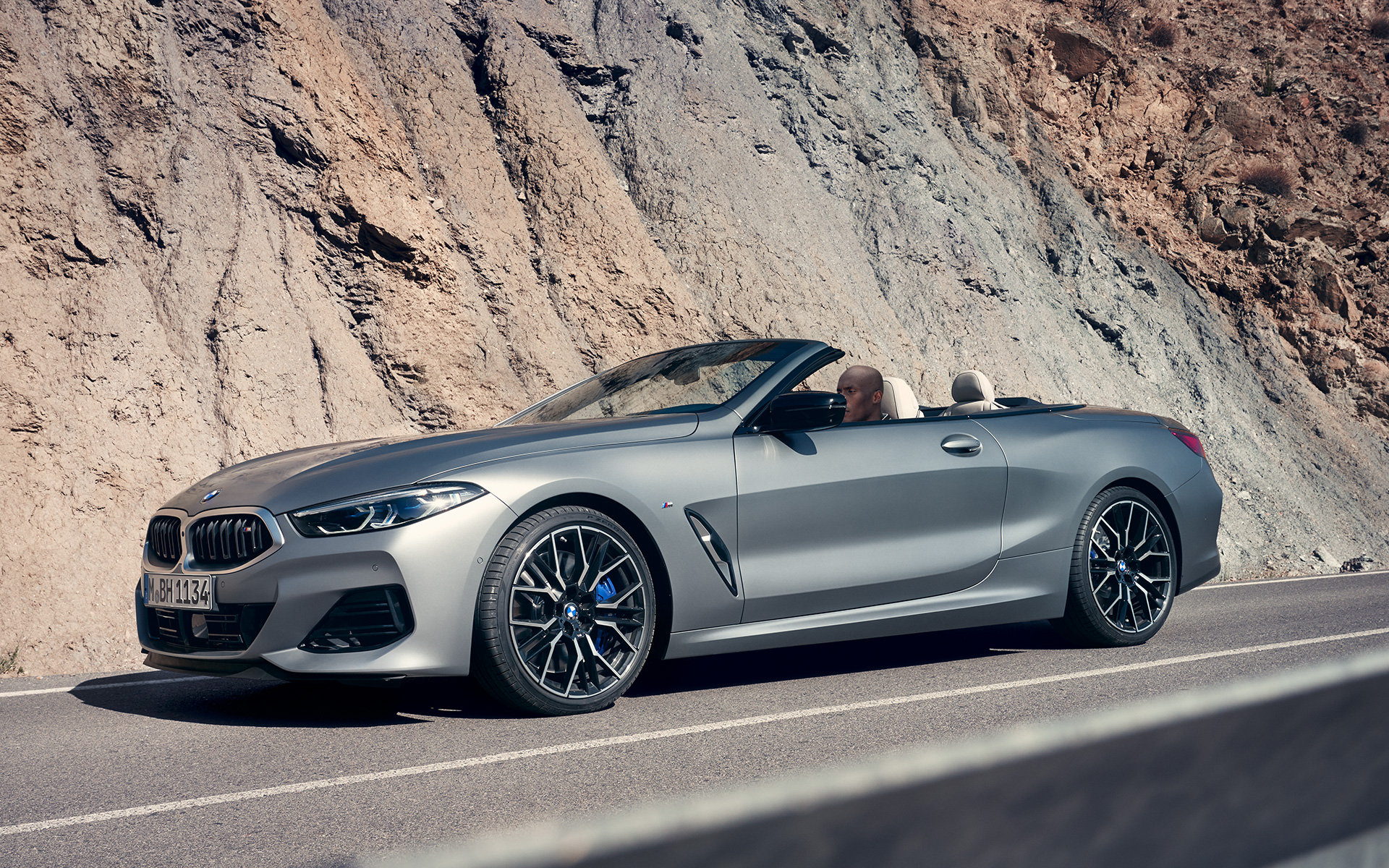 Perspetiva frontal a três quartos, BMW M850i xDrive Cabrio, G14, LCI, atualização, 2022 BMW M850i xDrive Cabrio, G14, LCI, atualização, 2022, pintura cinza Frozen Pure BMW Individual metalizada, perspetiva frontal três quartos, em movimento em frente a um penhasco