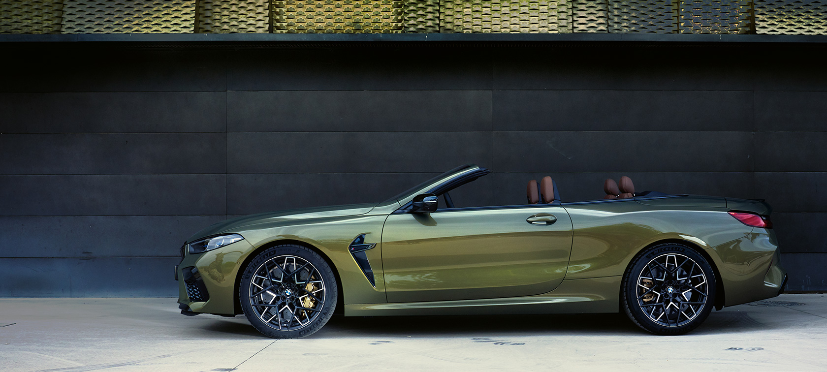 BMW M8 Competition Cabrio, F91, LCI, atualização, 2022, perspetiva lateral, parado BMW M8 Competition Cabrio, F91, LCI, atualização, 2022, pintura Brass BMW Individual metalizada, perspetiva lateral, parado com a porta aberta e um modelo feminino