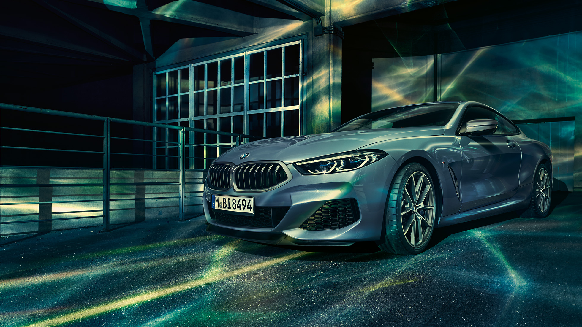 BMW M850i xDrive Coupé, perspetiva frontal a três quartos. BMW M850i xDrive Coupé na pintura azul Barcelona metalizada, parado em frente de um edifício, perspetiva frontal a três quartos.