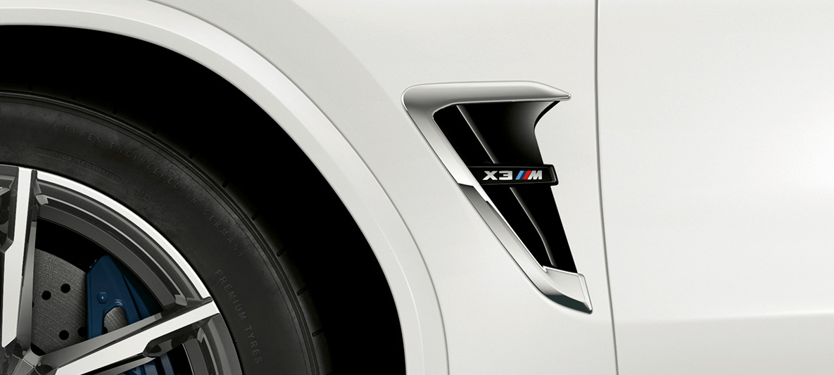BMW X3 M, grelha lateral M. BMW X3 M na pintura branco Alpine, exterior, grelhas laterais M com realces em cromado e designação do modelo.