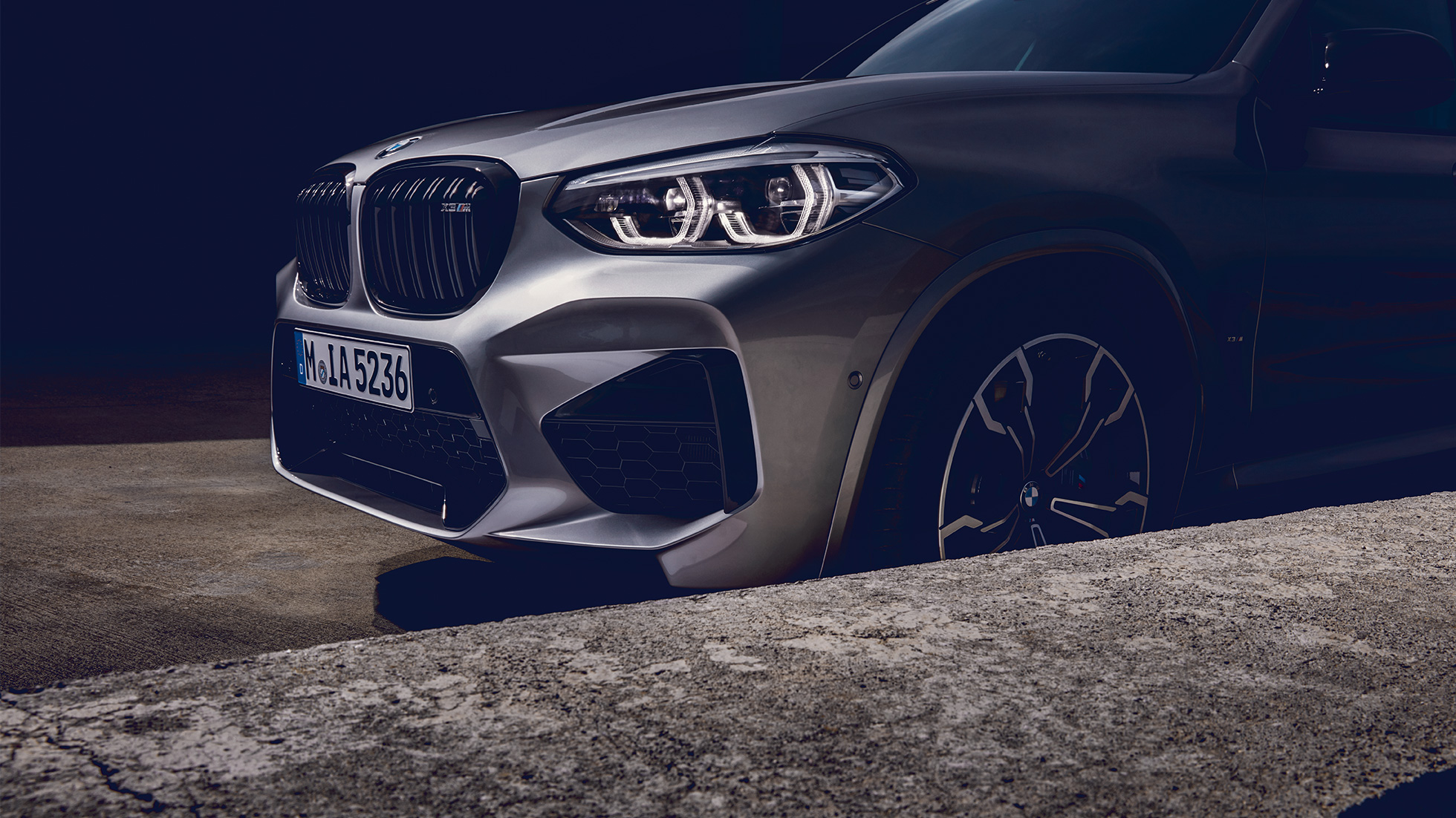 BMW X3 M Competition, perspetiva frontal lateral. BMW X3 M Competition na pintura cinza Donington metalizada, exterior, perspetiva frontal a três quartos.
