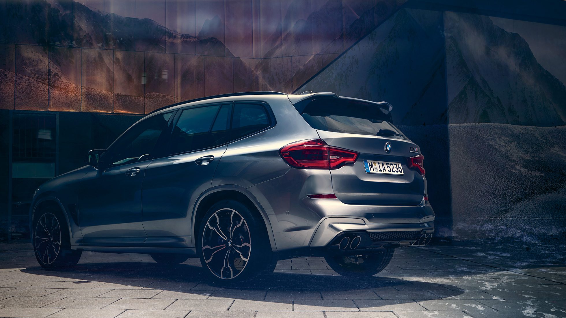 BMW X3 M Competition, perspetiva traseira lateral. BMW X3 M Competition na pintura cinza Donington metalizada, exterior, perspetiva traseira lateral.
