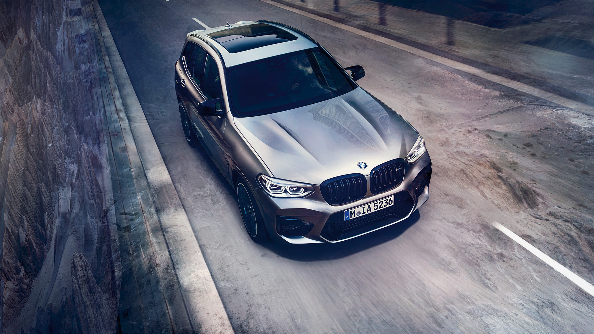 BMW X3 M Competition, perspetiva de topo. BMW X3 M Competition na pintura cinza Donington metalizada, exterior, perspetiva de topo da dianteira.