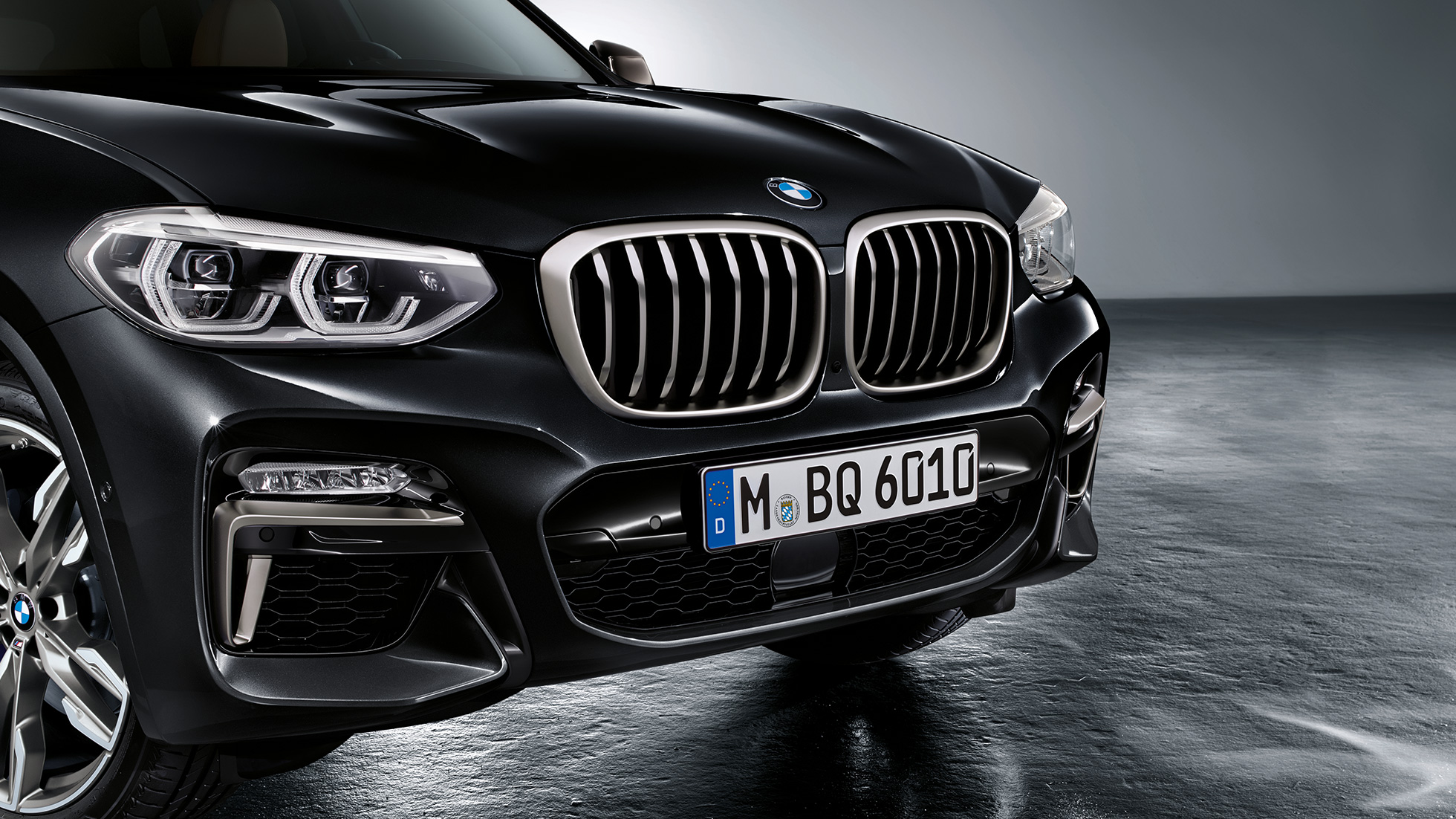 BMW X3 M40d, dianteira. BMW X3 M40d na pintura preto Sapphire metalizada, exterior, dianteira com pormenores de design em cinza Cerium.