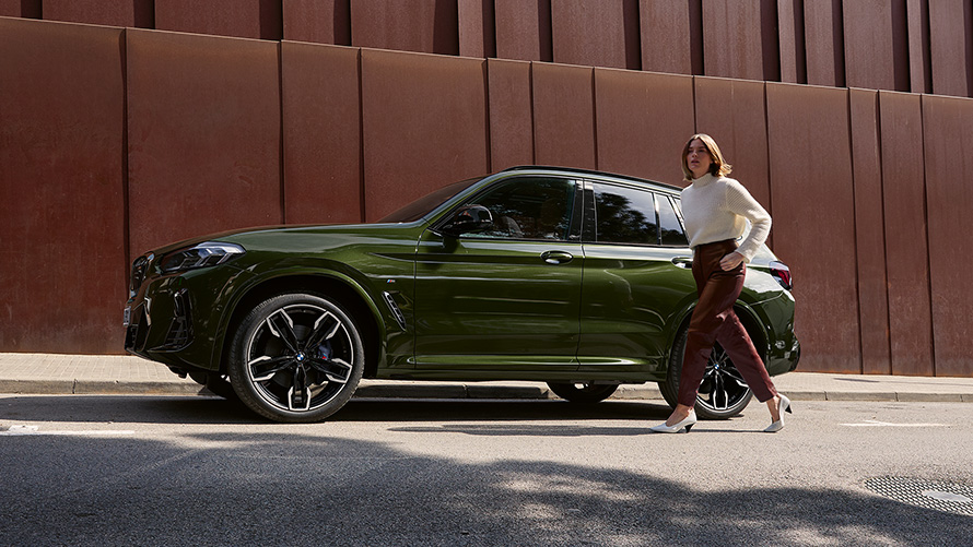 BMW X3 M40i, G01, LCI, atualização, 2021, cor exterior verde Malachite metalizada, perspetiva lateral, com um modelo feminino