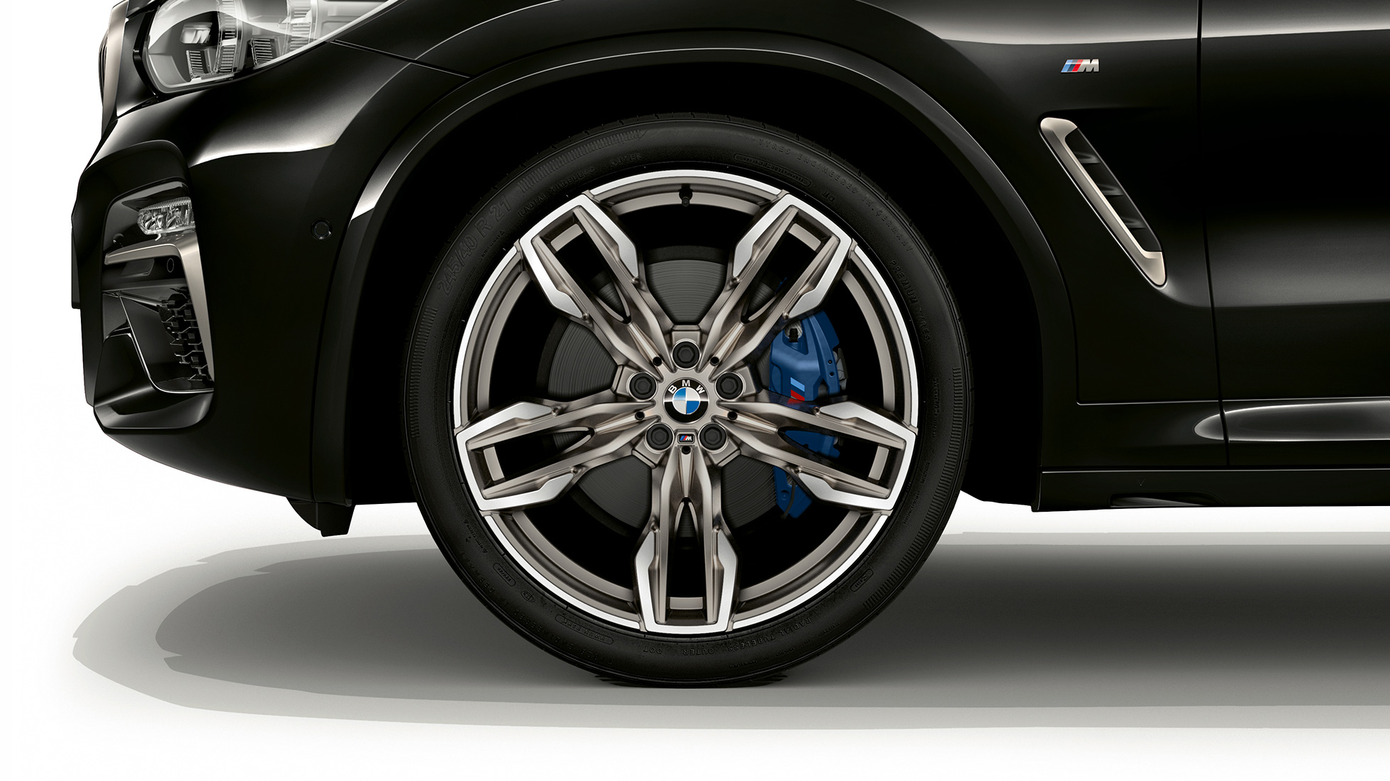 BMW X4 M40d, jantes de liga leve M de raios duplos de 21". BMW X4 M40d na pintura preto Sapphire metalizada, exterior, perspetiva lateral com jantes de liga leve M de raios duplos de 21".