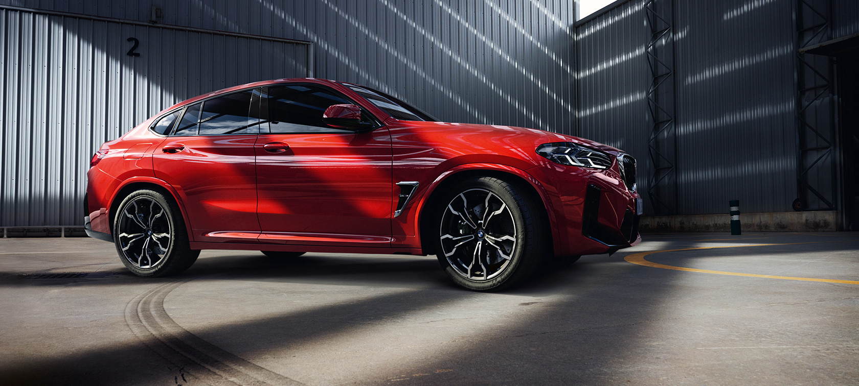 Perspetiva frontal a três quartos, BMW X4 M, F98, LCI, atualização, 2021 BMW X4 M, F98, LCI, atualização, 2021, cor exterior vermelho Toronto metalizada, perspetiva frontal a três quartos, no interior de um edifício de uma fábrica