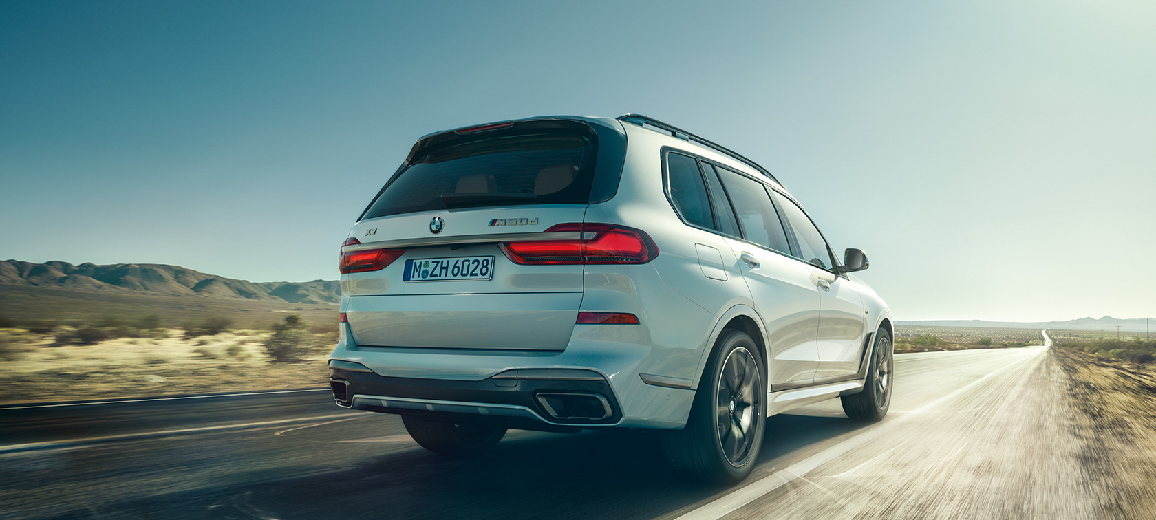 BMW X7 M50d, perspetiva traseira BMW X7 M50d em branco Mineral, G07, numa autoestrada vazia, perspetiva traseira, G07, 2019