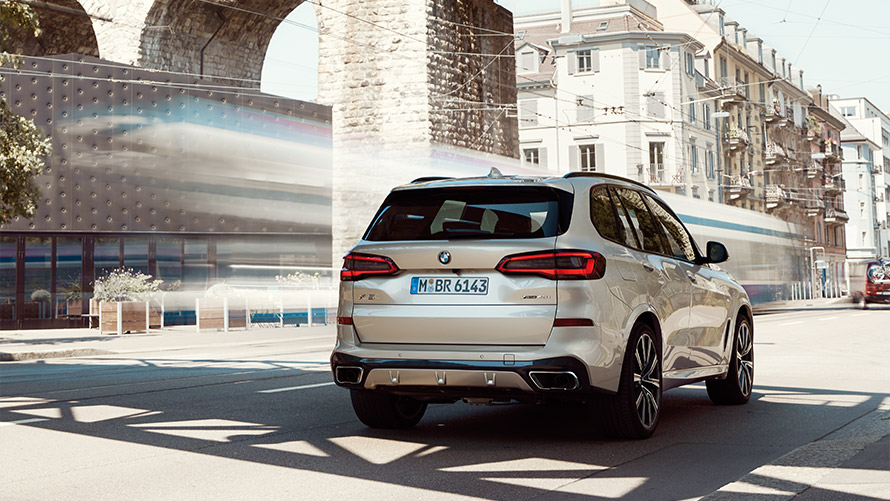 BMW X5, G05, quarta geração, perspetiva traseira a três quartos, parado à frente de um edifício Modelos BMW X, BMW X5, G05, quarta geração, perspetiva traseira a três quartos, parado à frente de um edifício