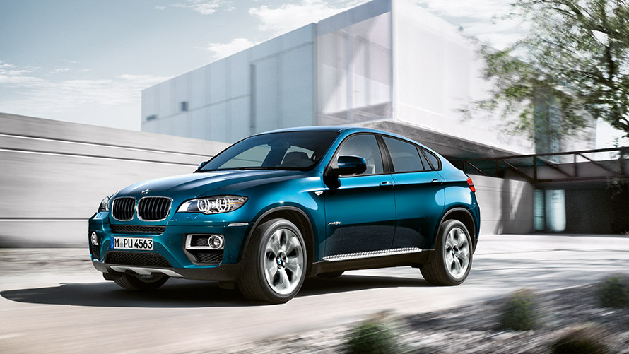 BMW X6, E71, primeira geração, perspetiva lateral a três quartos, parado à frente de um edifício Modelos BMW X, BMW X6, E71, primeira geração, perspetiva lateral a três quartos, parado à frente de um edifício
