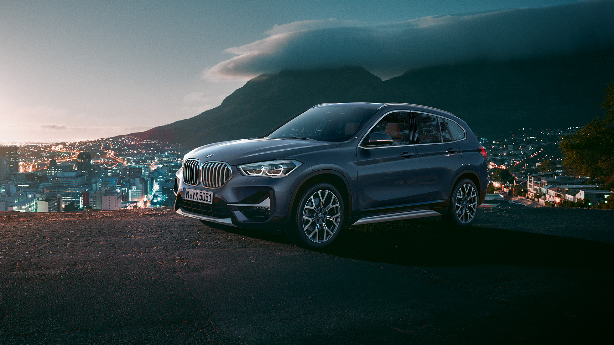 BMW X1, perspetiva lateral a três quartos. BMW X1, perspetiva lateral a três quartos, em frente a um cenário urbano.