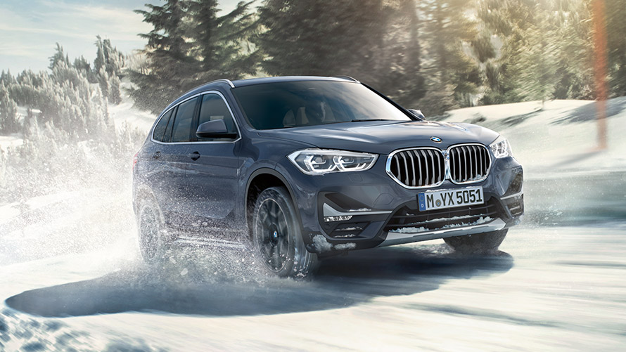 BMW X1 xDrive20i, F48, LCI, pintura Storm Bay BMW Individual metalizada, em movimento numa paisagem de inverno BMW X1 xDrive20i, F48, LCI, pintura Storm Bay BMW Individual metalizada, em movimento numa paisagem de inverno
