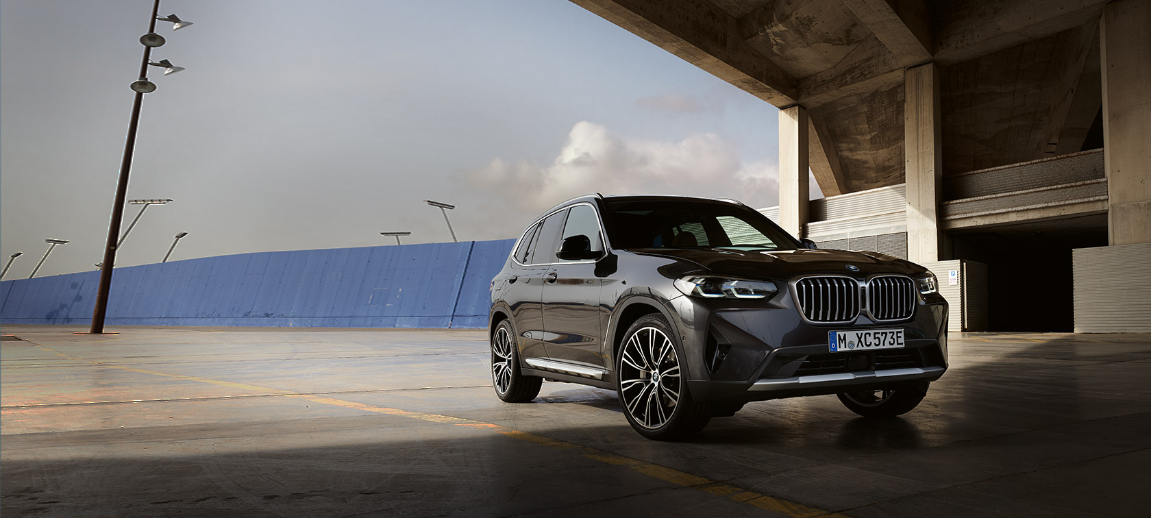 BMW X3, G01, cor exterior cinza Sophisto, perspetiva frontal a três quartos, em frente a um hangar, 2021