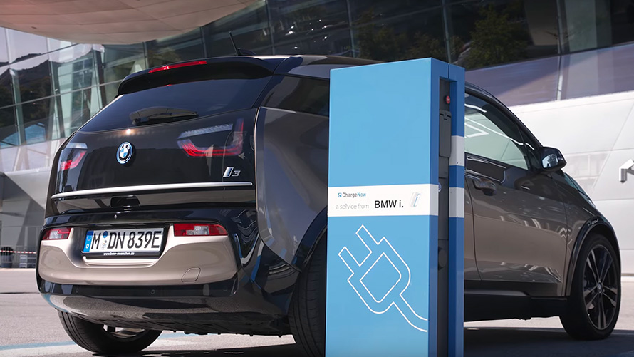 BMW i3 num posto de carregamento BMW i3 num posto de carregamento, perspetiva traseira a três quartos