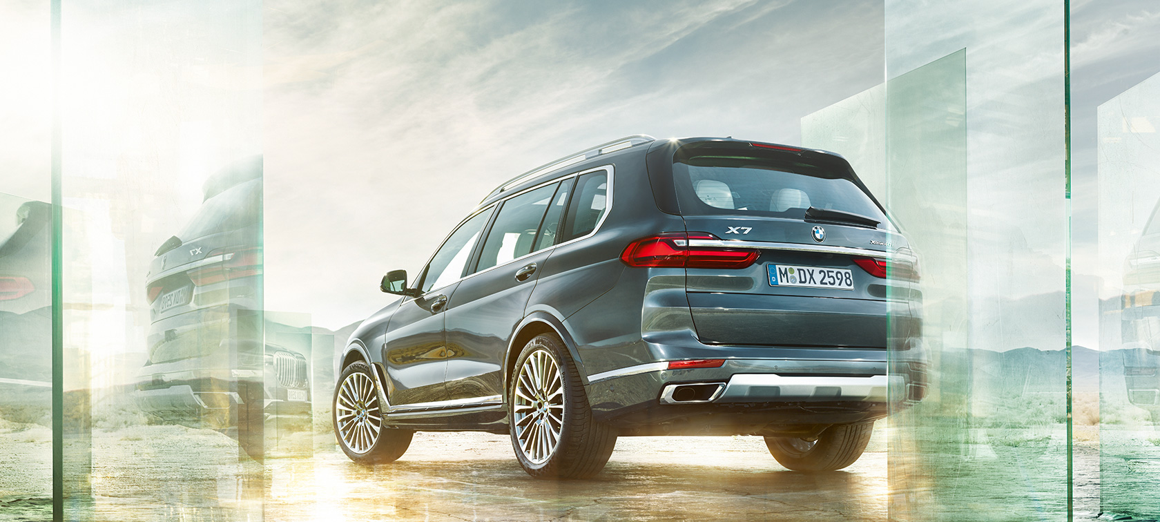BMW X7, perspetiva traseira a três quartos BMW X7 em cinza Artic, perspetiva traseira a três quartos em frente a uma paisagem de deserto, G07 2019