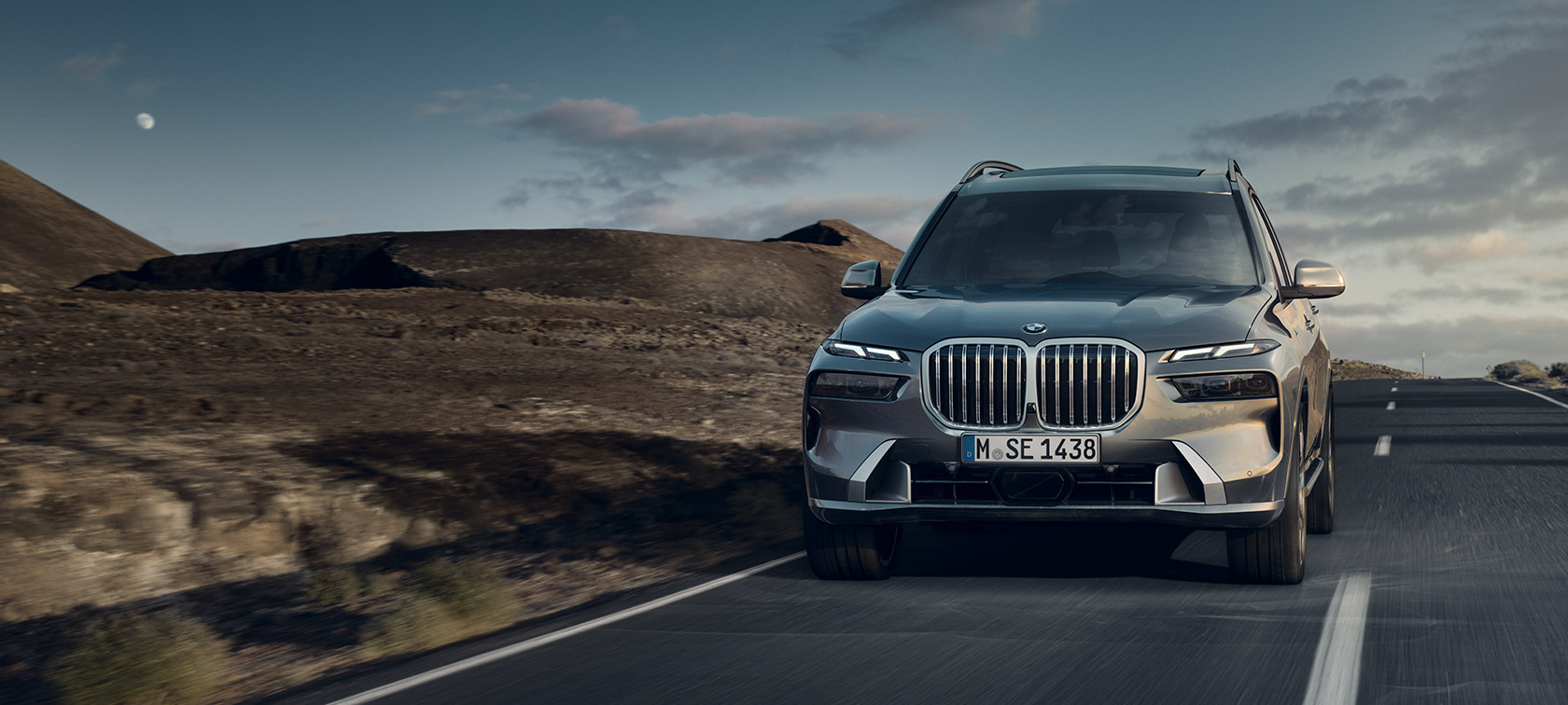 BMW X7, G07, LCI, perspetiva dianteira 7/8, em movimento, pintura cinza Sparkling Copper metalizada