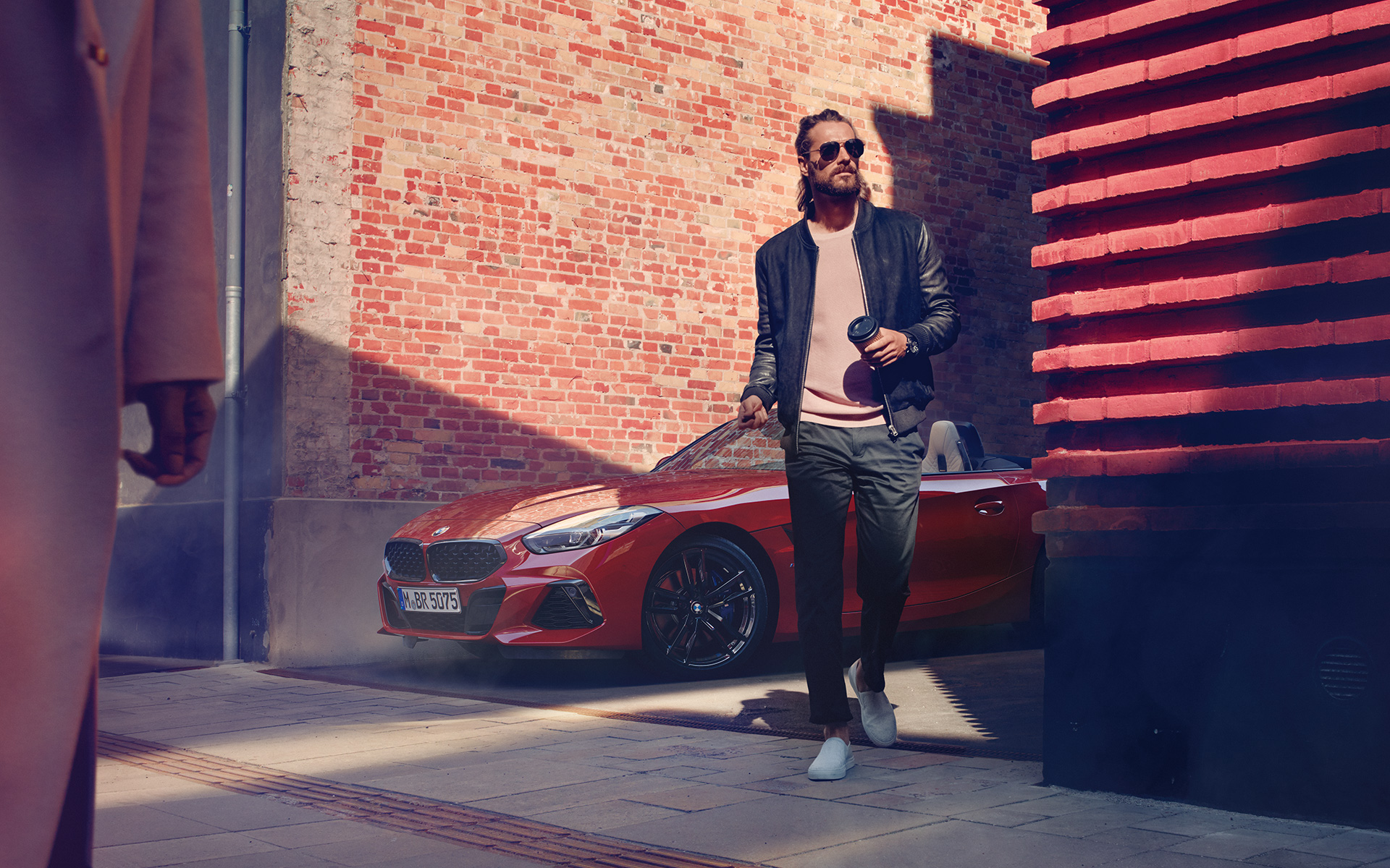BMW Z4 Roadster (G29) numa rua secundária Um homem numa rua secundária à frente do BMW Z4 Roadster (G29)