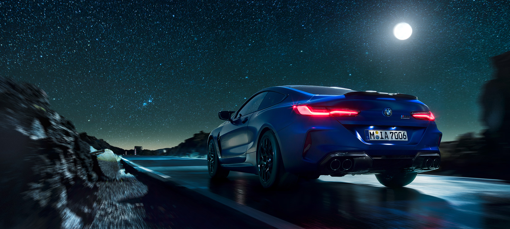 BMW M8 Competition Coupé, perspetiva traseira. BMW M8 Competition Coupé, perspetiva traseira, conduzido durante uma noite de lua cheia