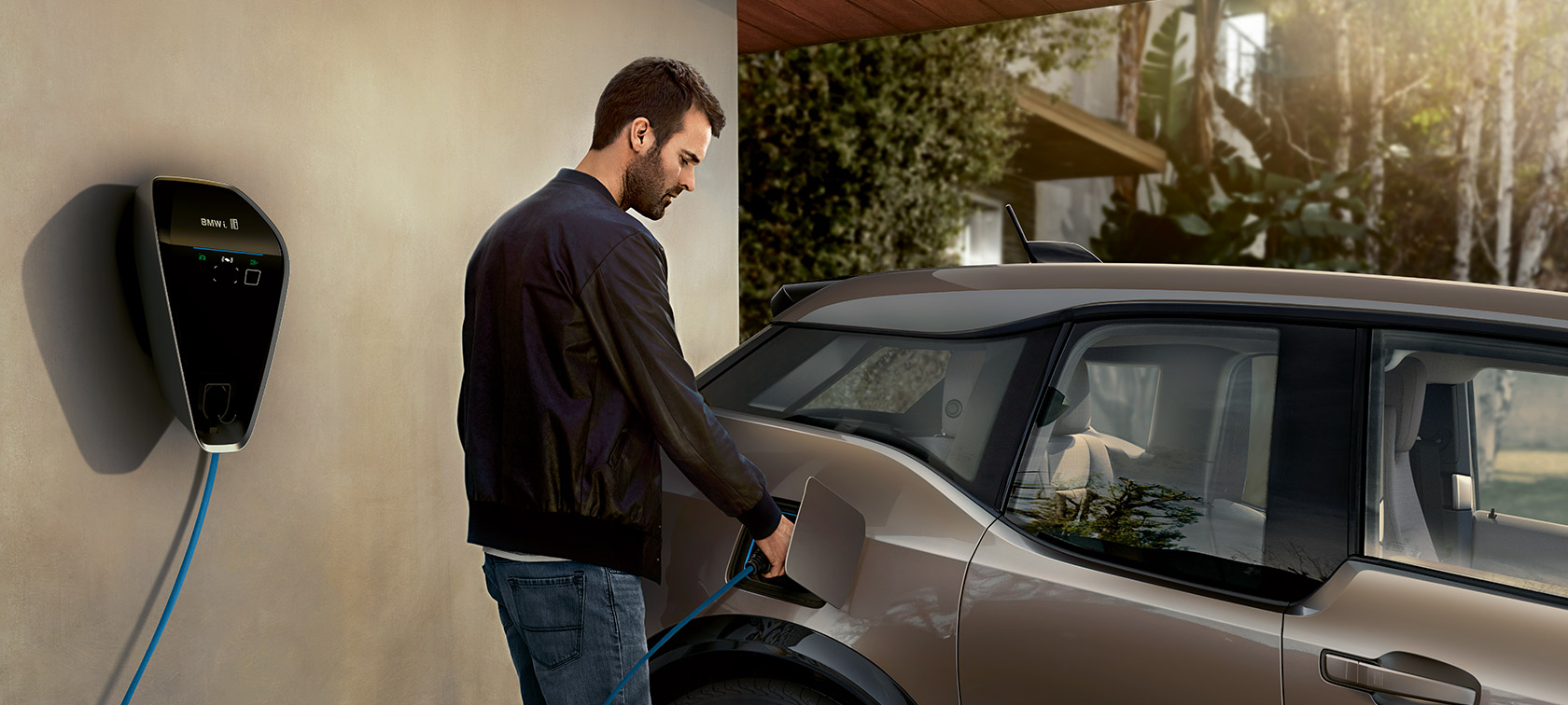 Um homem carregar o BMW i3. Um homem carrega o BMW i3 na BMW i Wallbox.