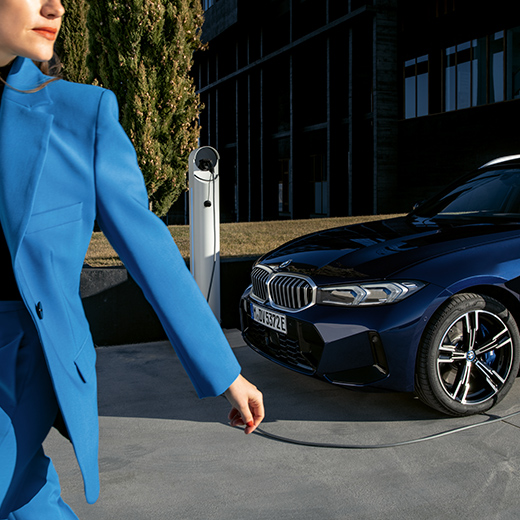 Cenário de carregamento com BMW, mulher a andar em primeiro plano
