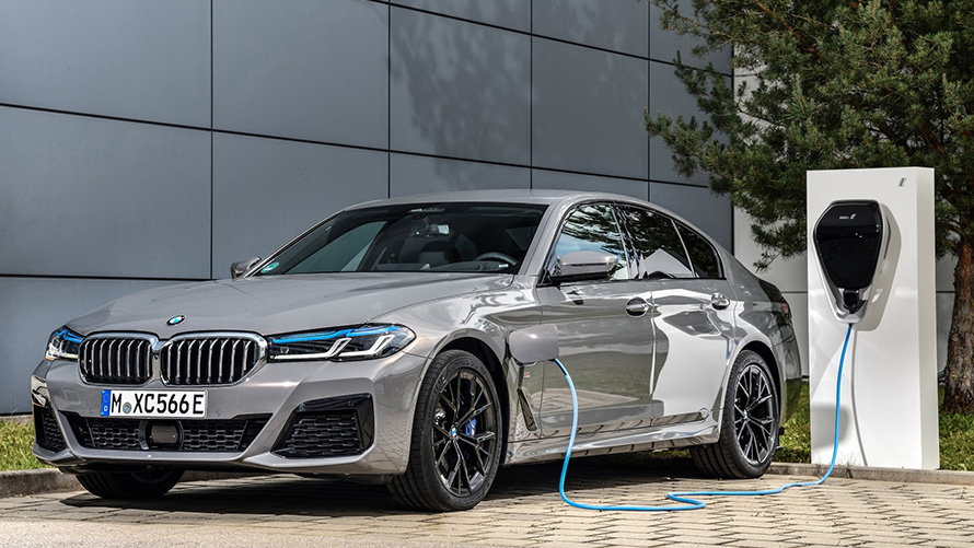 Atualização de software à distância, veículo híbrido BMW num posto de carregamento Atualização de software à distância, veículo híbrido BMW num posto de carregamento, perspetiva frontal a três quartos