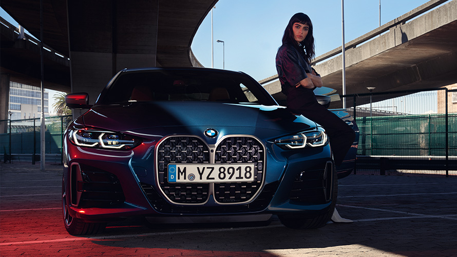 Mulher encostada a um BMW Série 4 Coupé Atualização de software à distância, mulher encostada a um BMW Série 4 Coupé