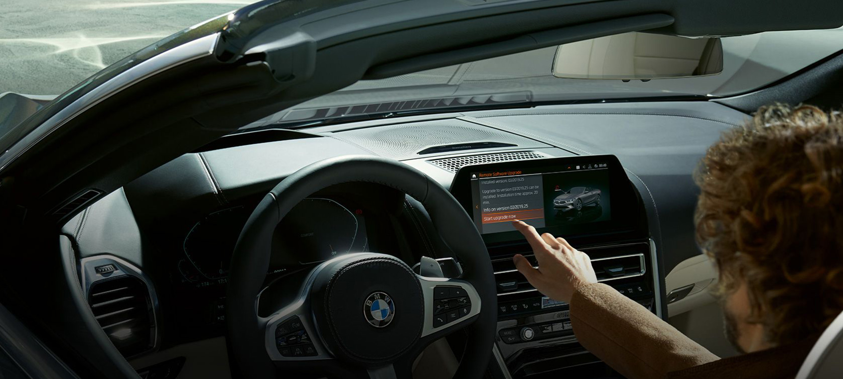Atualização de software à distância BMW Homem sentado num BMW a iniciar a atualização de software à distância BMW