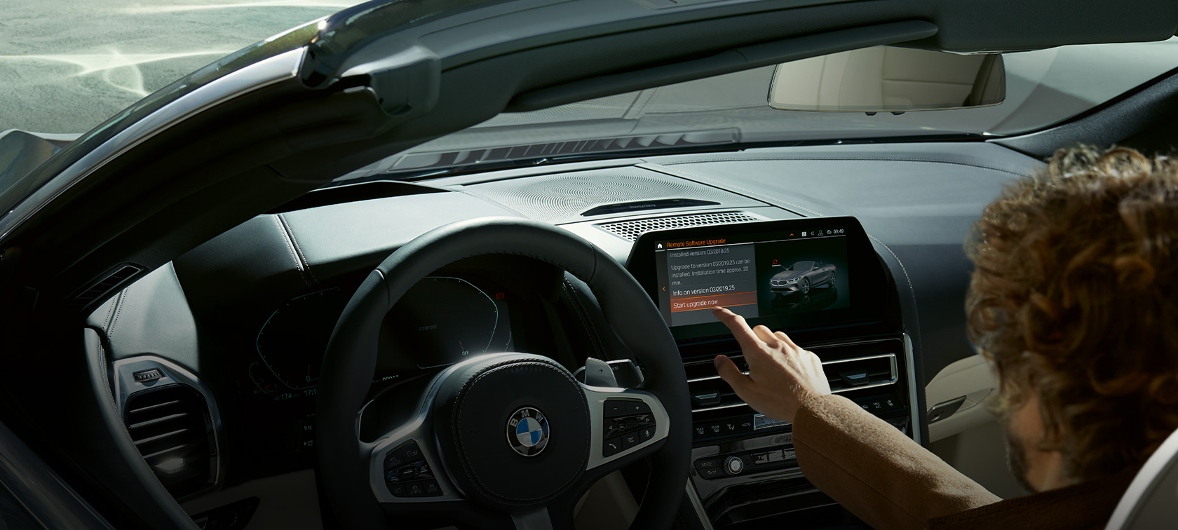 Atualização de software à distância BMW Homem sentado no BMW a iniciar a atualização de software à distância BMW