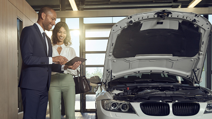 Revisão e Manutenção Uma cliente do Serviço BMW e colaboradores do Serviço BMW debatem a revisão e a manutenção