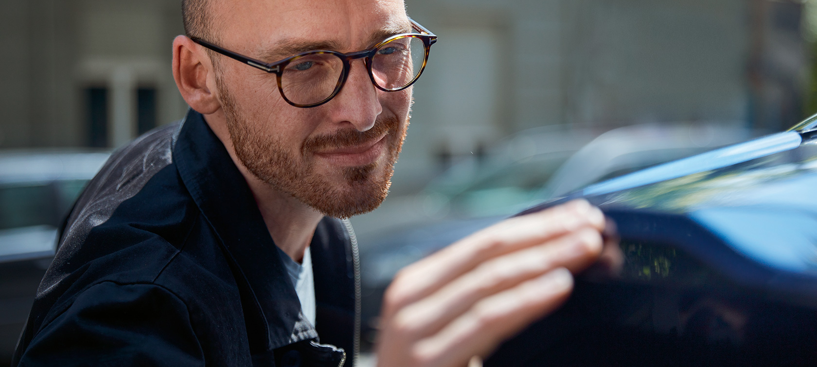Um homem a passar a mão pelo seu BMW para sentir eventuais imperfeições. Um homem a passar a mão pelo seu BMW para sentir eventuais imperfeições.