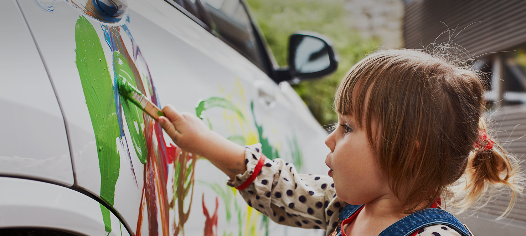 Uma menina está a colorir um BMW branco. Uma menina está a colorir um BMW branco.