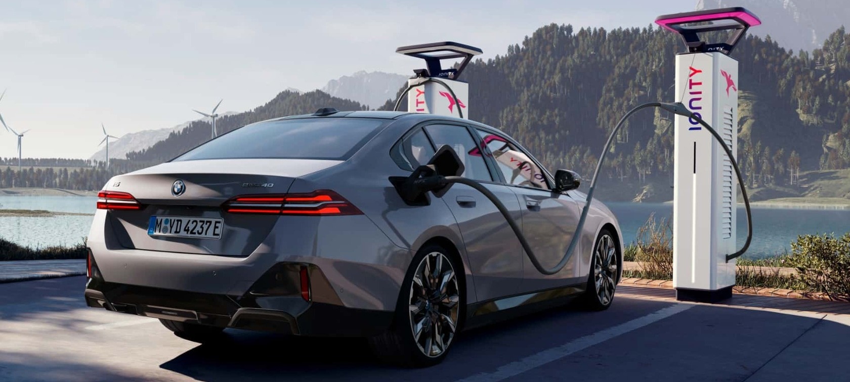 Postos ultrarrápidos IONITY - BMW BMW i5 eDrive40 num posto de carregamento IONITY com um fundo da Natureza.