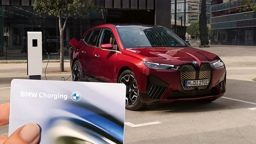 Carregamento público com o cartão de carregamento BMW Pessoa com o cartão de carregamento BMW num posto de carregamento público