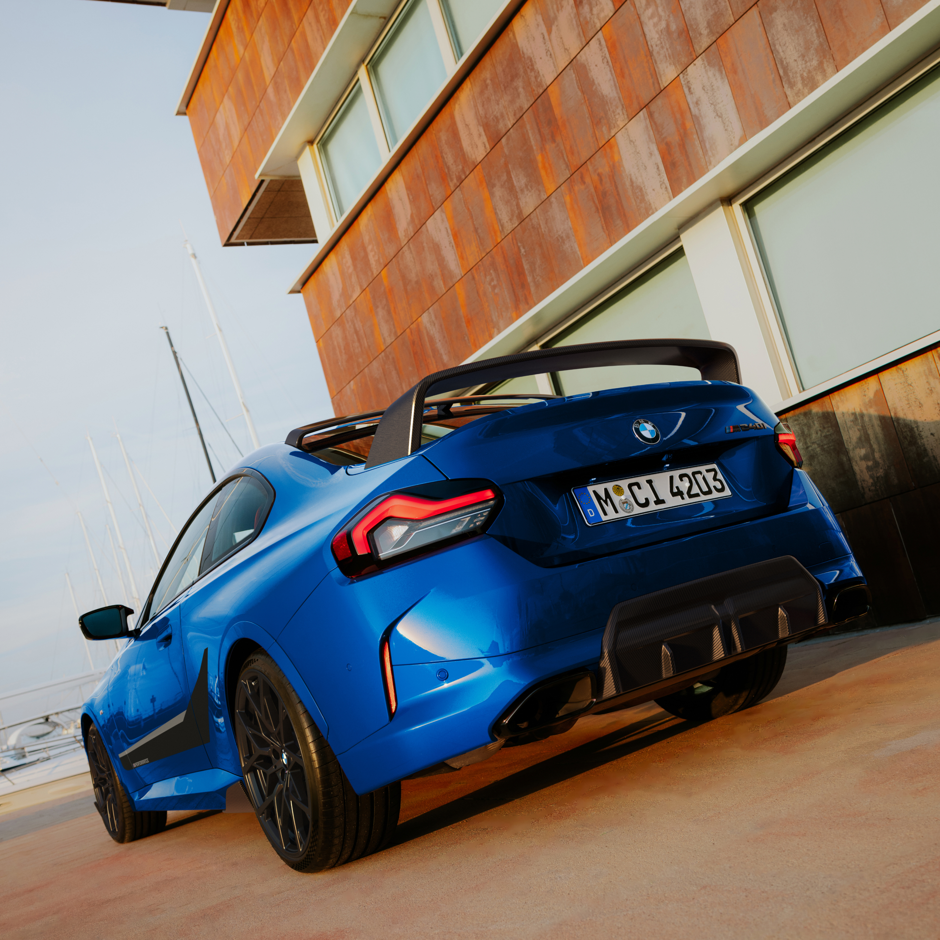 BMW com spoiler traseiro M Performance estacionado em frente a uma casa