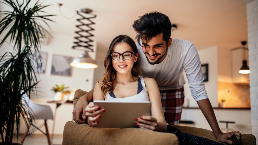 Duas pessoas sentadas a olhar para um tablet.