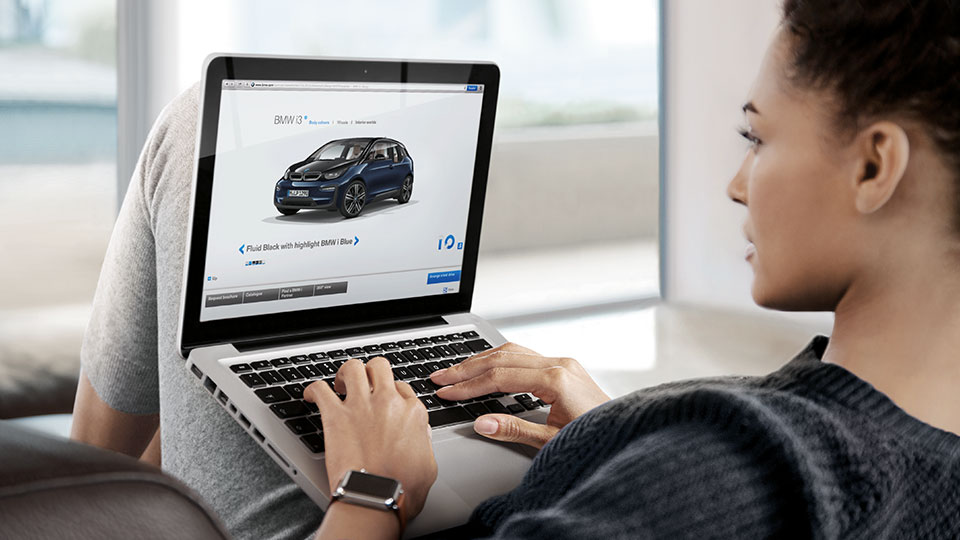 Woman configures the BMW of her choice on the laptop Woman configures the BMW of her choice at home on the laptop